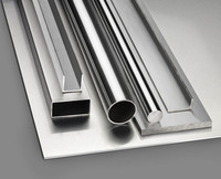 Glänzende Metallbleche, -rohre und -stangen, die auf einer flachen Oberfläche angeordnet sind.